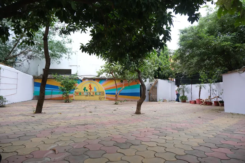 Shaded courtyard with trees and a rainbow wall