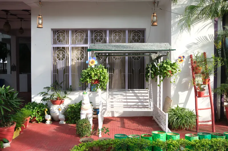 Entrance porch with a white swing and plants